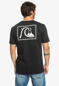 Black cotton t-shirt featuring a large white graphic of a wave and a mountain in a checkered box on the back. Short sleeves and crew neck design.