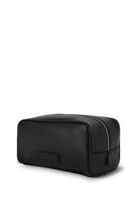 Czarna skórzana kosmetyczka o teksturowanej powierzchni, prostokątnym kształcie i srebrnym zamku błyskawicznym. Posiada firmową skórzaną naszywkę z przodu.