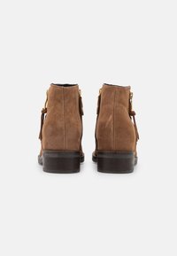 Ruske nubuk ankle boots med rund tå, lav stable hæl og guld lynlåsdetalje. Har kvastdetalje på siden.