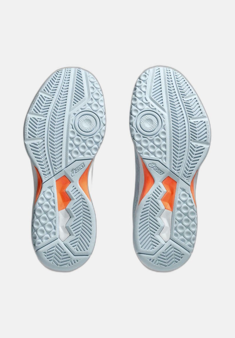 Soli di scarpe da ginnastica bianche con gomma testurizzata, caratterizzati da un design geometrico arancione e motivi di battistrada distintivi per aderenza e stabilità.