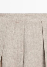 Beige linnenstof met verticale plooien en een tailleband, met subtiele textuur en natuurlijke vezels.