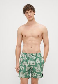 Πράσινα μαγιό κολύμπι με σχέδιο από ανοιχτόχρωμα αφηρημένα σχήματα και φύλλα. Τα σορτς διαθέτουν ελαστική μέση και κορδόνι.