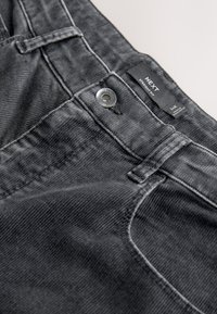 Pantalon gris coupe droite avec un tissu texturé, doté d'une fermeture à bouton métallique et d'une étiquette indiquant la taille 34R.