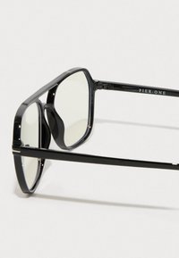 Mustad mustaga läikega päikeseprillid, millel on teravad servad ja selged läätsed, ning käepidemes on "PIER ONE" brändi märgistus.