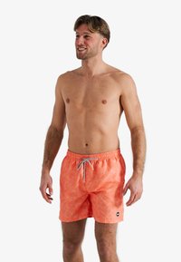 Zwemshorts in fel koraal met een bladvormig patroon, voorzien van een elastische tailleband en een trekkoord voor een verstelbare pasvorm.