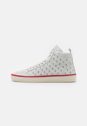 Hvid højtop sneaker med metalnitter, hvide snørebånd, rød kant over beige sål og en trække-flig ved hælen på en ensfarvet baggrund.