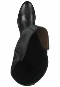 Bottine en cuir noir avec une texture lisse, bout arrondi et panneaux latéraux élastiques. Intérieur doublé de tissu marron. Design minimaliste.