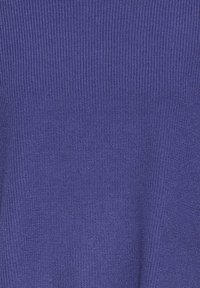 Gros plan sur un tissu tricoté bleu avec une texture côtelée et un motif de points fins et réguliers.