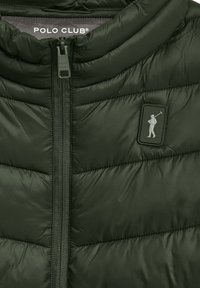 Mörkgrön puffjacka med hög krage, framdragkedja och en texturerad quiltad design. Har en logotypapplikation som visar en golfspelare.