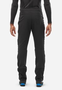 Pantalons d'extérieur noirs avec une coupe ajustée, poches zippées et sections renforcées aux genoux. Le matériau semble durable et flexible.