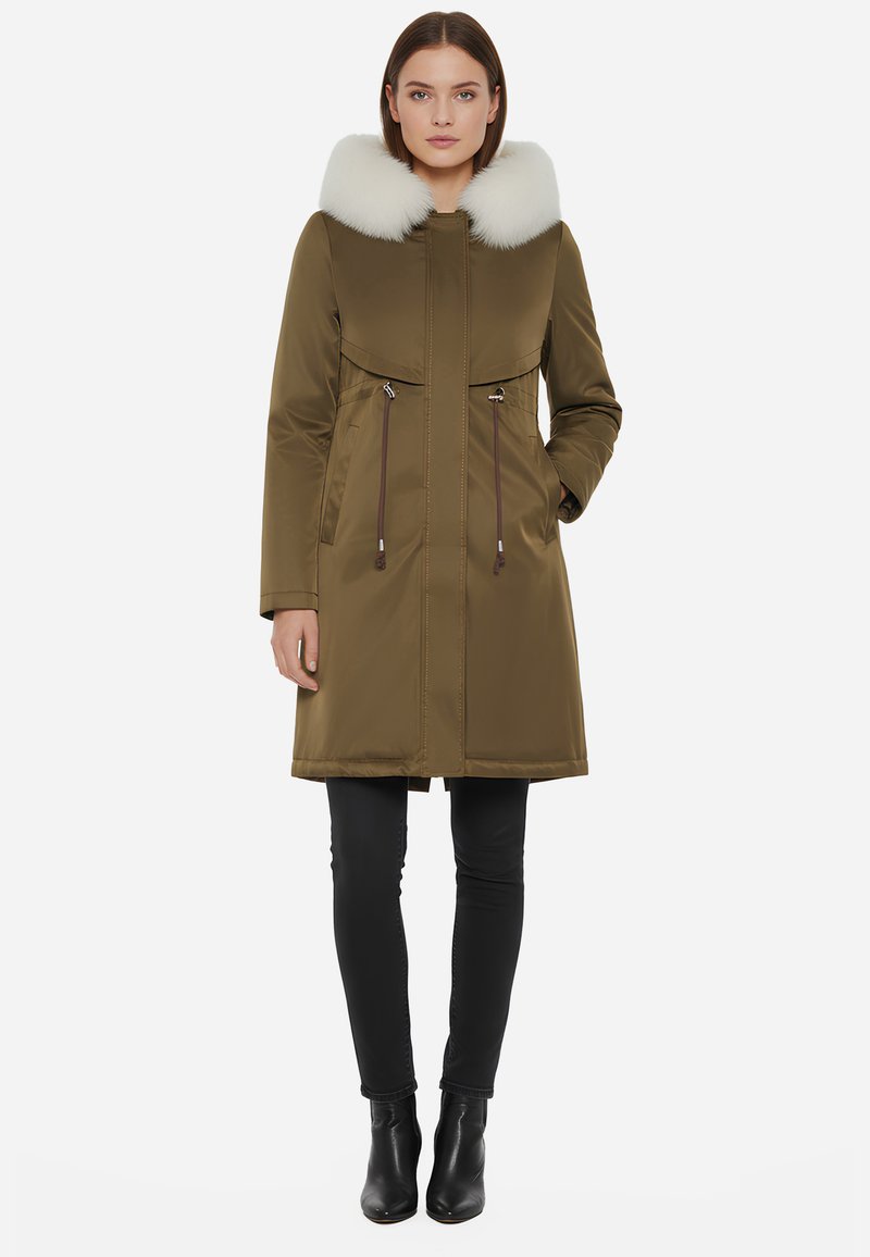 Parka verde oliva con colletto in pelliccia bianca staccabile, chiusura frontale con zip, due tasche con zip e vita regolabile con coulisse.