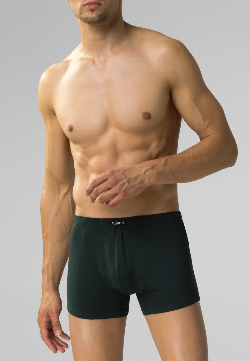 Ciemnozielone bokserki z czarnym paskiem, wykonane z miękkiego materiału, z dopasowanym krojem i minimalnymi detalami przeszyć.