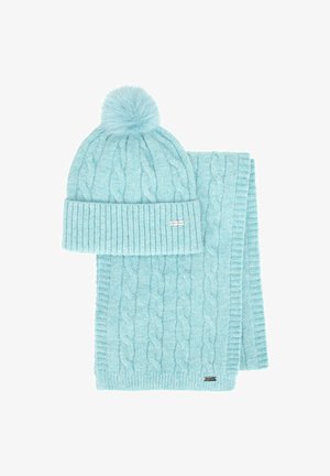 Gorro de punto azul claro con un pompón y bufanda a juego, ambos con un patrón de trenzas y bordes acanalados, hechos de hilo suave.