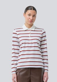 Langermet polo-skjorte i hvitt med røde og blå horisontale striper, kragehals, og knappedetalj foran.