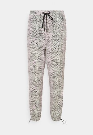 Pantalon ample de couleur claire avec motif abstrait de cercles noirs, taille élastique avec cordon noir et chevilles ajustables avec boucles de corde noire.