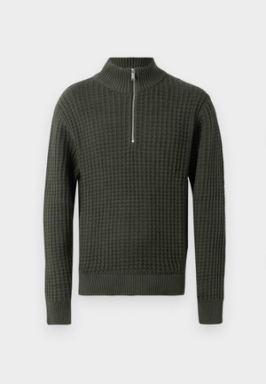 Žalias megztas džemperis su aukštu apykakle ir pusiau užtrauktuku. Yra tekstūruota rašto detalė, o rankogaliai ir apačia yra su raukiniais.