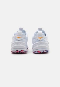 White athletic shoes with textured material, rear pull tabs, orange accents, and a colorful patterned sole featuring purple, pink, and white.