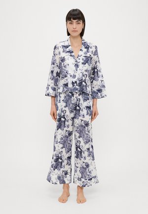 Ensemble de pyjama à imprimé floral en blanc et marine, comprenant un haut à boutons avec col et un pantalon à jambes larges. Tissu doux avec une finition lisse.