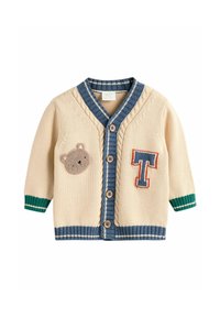 Beige Strickjacke mit einem blauen gerippten Kragen, grünen gestreiften Bündchen und einem Bären-Patch mit einem gestickten "T" auf der Vorderseite.