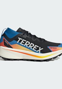 Schwarzer Sportschuh mit einer strukturierten Oberseite, verziert mit blauen, orangefarbenen und gelben Akzenten. Die Sohle ist weiß mit einem schwarzen Profilmuster.