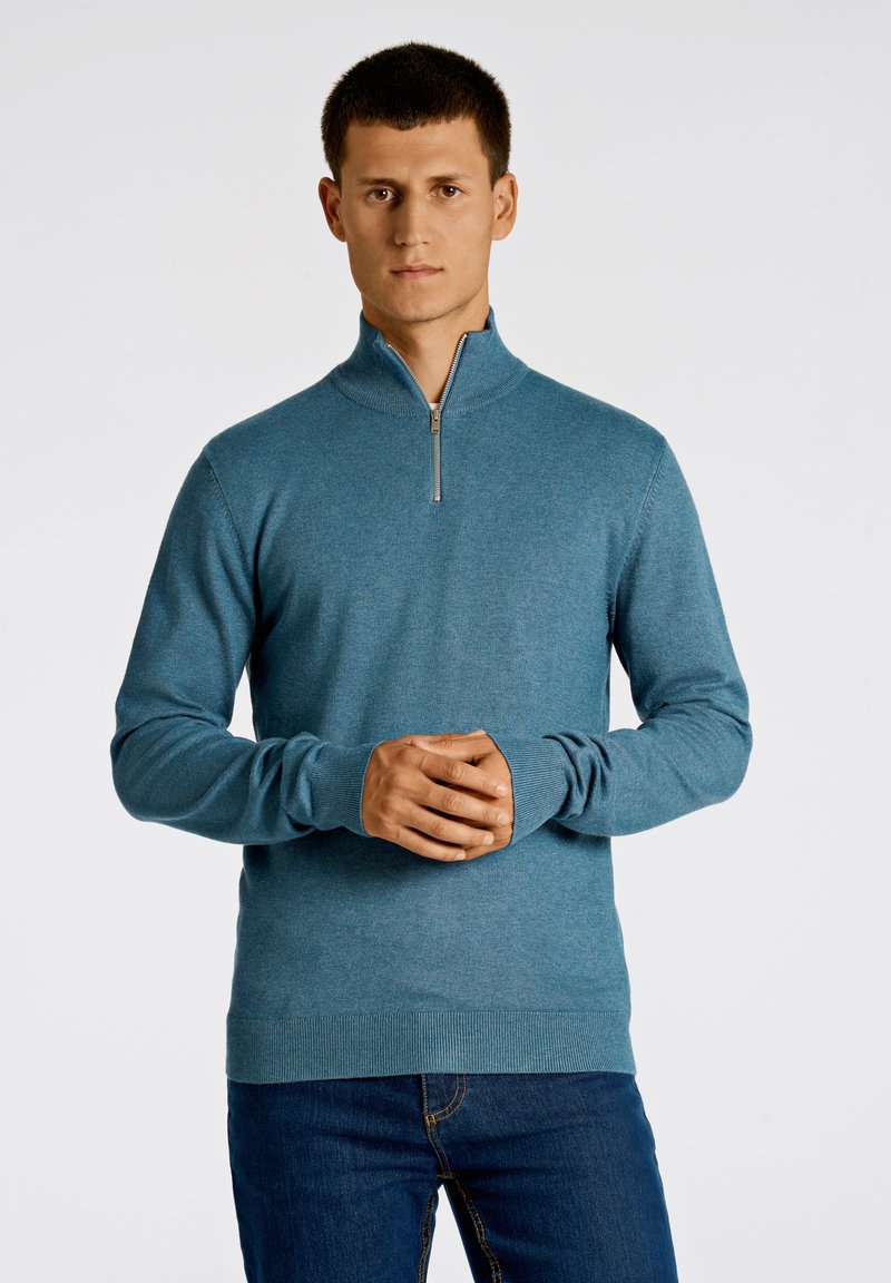 Herrtröja i teal med dragkedja vid kragen, långa ärmar, ribbade cuffs och fåll. Tillverkad i ett mjukt material med en slät yta och figursydd passform.