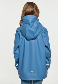 Blå vattentät jacka med huva, med en jämn yta och en reflexrem på ärmarna. Logotyp tryckt på baksidan.