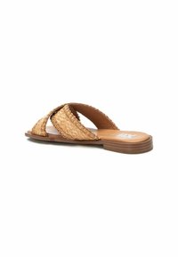 Sandalia sin hebillas de fibra natural con diseño de tiras cruzadas en marrón claro y detalles texturizados; suela plana con un ligero acabado de madera.