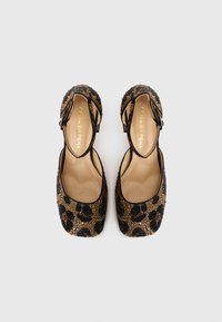Black and gold embellished ballet flats featuring a leopard print pattern, an enclosed toe design, and a small heel.