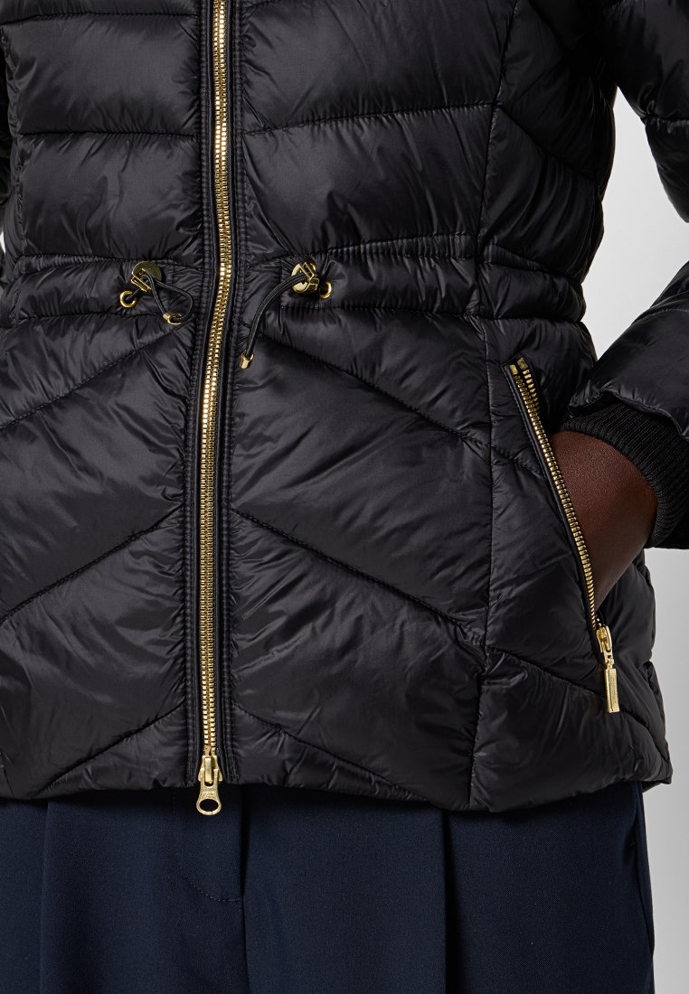 Schwarze Daunenjacke mit Zickzack-Steppdesign, goldenen Reißverschlüssen, verstellbarem Kordelzug in der Taille und seitlichen Reißverschlusstaschen, die eine glatte Textur aufweist.