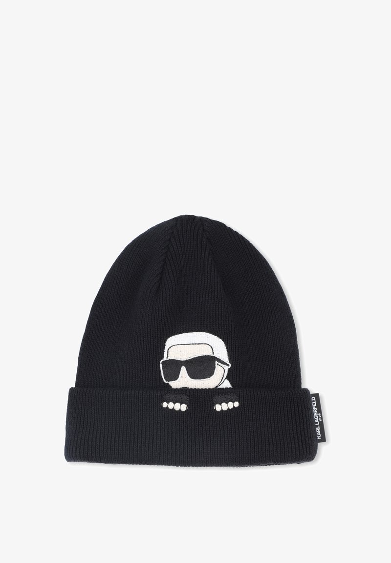Beanie lavorato a maglia nero con risvolto. Presenta un personaggio ricamato bianco che indossa occhiali da sole e tre punti bianchi sul risvolto.