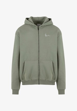 Zöld cipzáras kapucnis felső, puha anyagból készült, elülső zsebbel, bordás mandzsettákkal és egyszerű fehér logóval a bal oldalon.