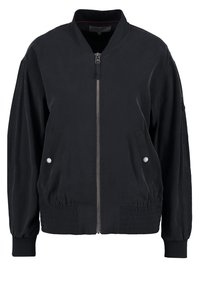 Chaqueta bomber negra de tejido suave, con cierre de cremallera en la parte delantera, dobladillo elástico, bolsillos laterales con botones de presión y puños acanalados.