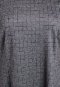 Grå tekstil med et ternet mønster og en subtil tekstur. Stoffet virker blødt, med et struktureret design og ensartede firkanter.