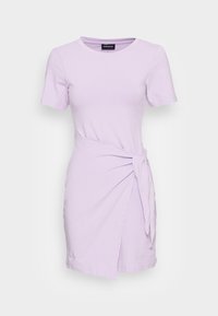 Lila kortärmad klänning med rund halsringning och sidoknytning. Tillverkad av mjukt tyg med omslagdesign och lätt utsvängd nederkant.