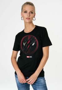 Black cotton t-shirt featuring a red and black graphic design of a crossed-out logo with scratch marks. Includes a small Marvel Studios tag.
