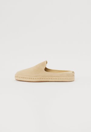 Beige Wildlederschlupfschuhe mit runder Spitze, Mittelsohle aus Jute-Seil und strukturiertem Gummiaußensohle. Einfaches Design, ohne sichtbare Befestigungen.