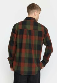 Flanellhemd in dunkelgrün, rot und schwarz kariert. Lange Ärmel, Knopfbündchen und eine Rückenfalte für zusätzlichen Bewegungsspielraum. Weicher, strukturierter Stoff.