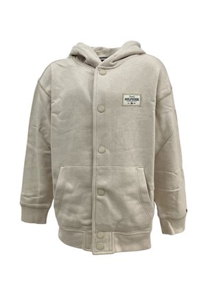 Giacca con cappuccio beige realizzata in tessuto misto cotone, dotata di chiusura con bottoni frontali, due tasche laterali e cappuccio. Patch con logo Tommy Hilfiger.