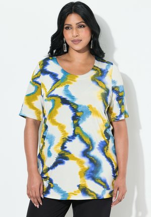 Haut à manches courtes multicolore en tissu doux avec un motif ondulé bleu, jaune et vert sur un fond clair ; encolure arrondie.