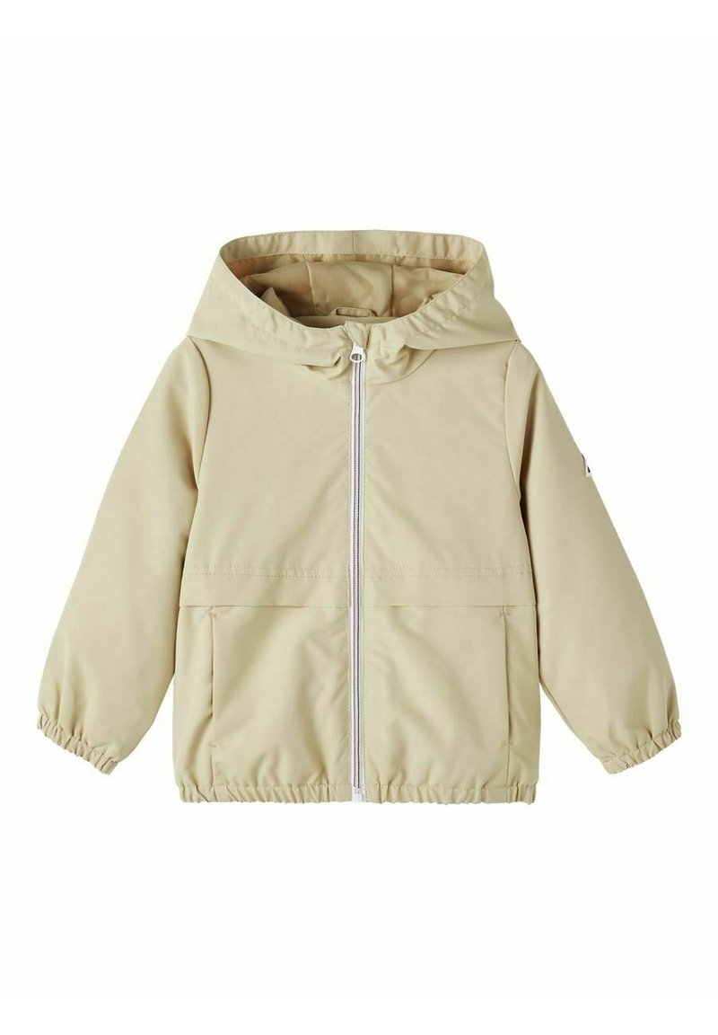 Giacca impermeabile beige chiaro con cappuccio, polsini elasticizzati, chiusura frontale con zip e una grande tasca. Texture liscia, design minimalista.