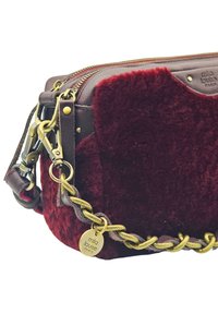 Sac à main en fausse fourrure bourgogne avec des accents en cuir marron, quincaillerie en or, bandoulière en chaîne tressée et fermeture éclair avec une étiquette de logo.