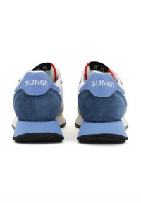 Sneaker blu e bianchi con tallone in suede, marchio sul tallone, suola in gomma e accenti rossi sul colletto e sulla linguetta.