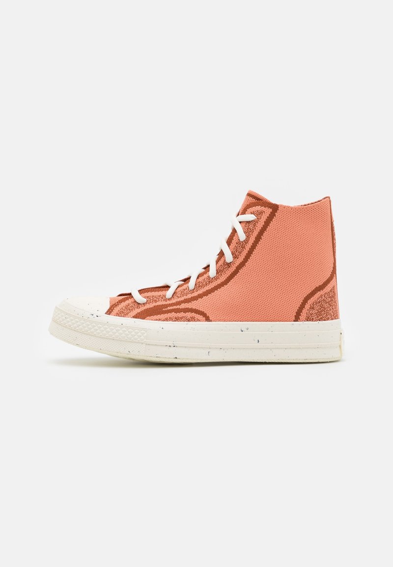 Baskets hautes en maille orange clair avec des lacets blancs et une semelle en caoutchouc texturée couleur blanc cassé.
