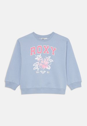 Lys blå genser med rund hals, lange ermer og et blomstertrykk i rosa og hvitt. Har ribbestrikkede cuffs og nederkant.