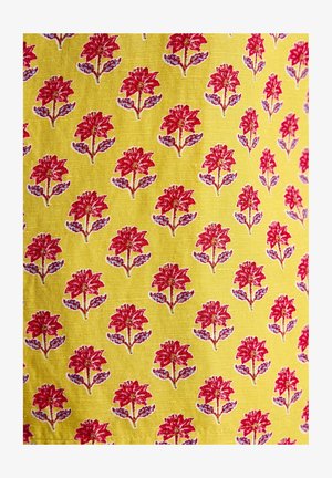Keltainen kangas, jossa on toistuva kuvio punaisista kukista vihreillä lehdillä. Suunnittelussa on yksityiskohtaisia kukkakoristeita ja teksturoitu pinta.