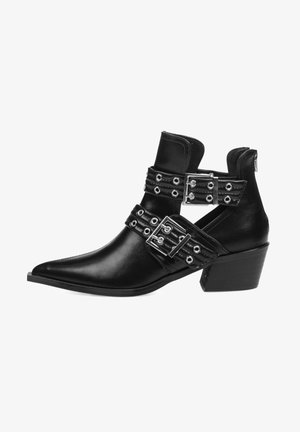 Botines de cuero negro hasta el tobillo con punta afilada, que cuentan con dos correas anchas con hebillas metálicas y ojetes, y un tacón bajo cuadrado.