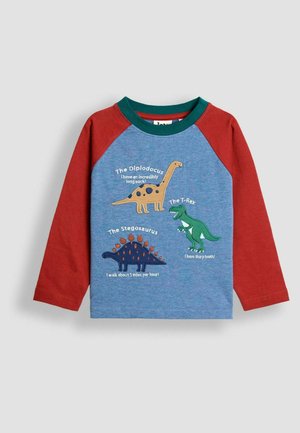 Detská košeľa s dlhým rukávom, červenými rukávmi, modrým telom a tlačenými ilustráciami dinosaurov vrátane diplodoka, T-Rexa a stegosaurusa s faktami.