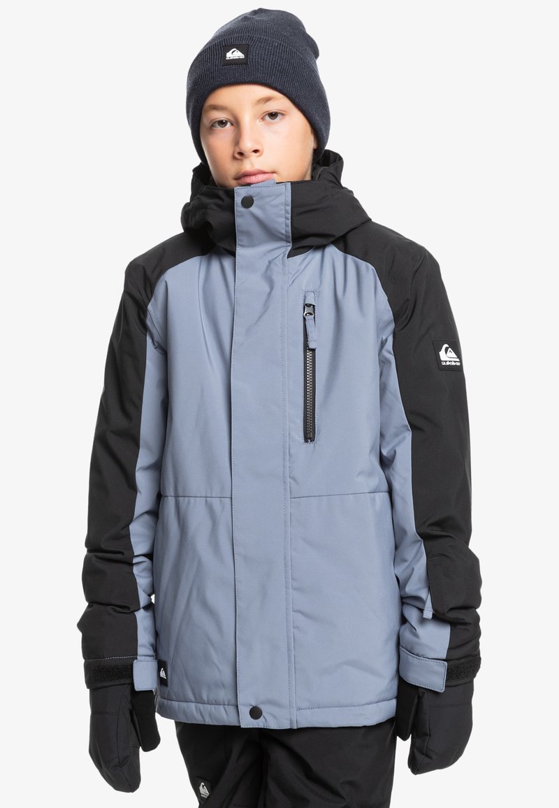 Isolierte Außenjacke in Hellblau und Schwarz, mit einer Reißverschlusstasche auf der Brust, verstellbaren Ärmelbündchen und einer Kapuze. Strukturierter Stoff für Wärme.