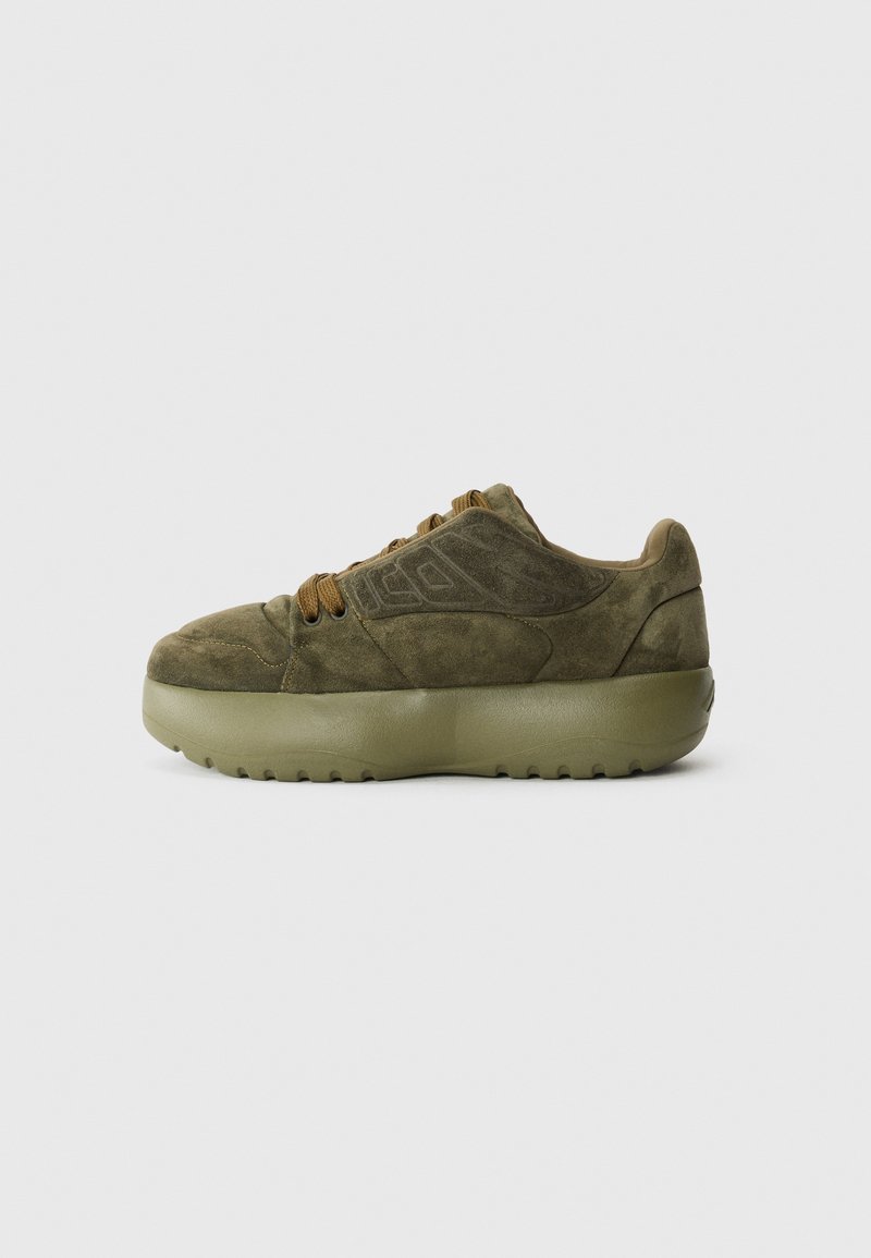 Olive green suede sneakers with a chunky rubber sole, rounded toe, and brown laces. Features embossed design on the side.