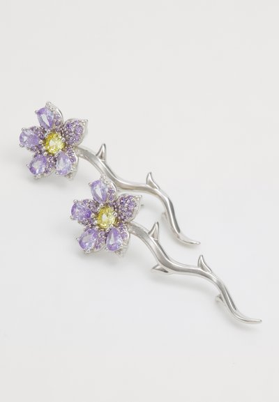 Sølv blomsterhårnål med to blomster, som har lilla og gule ædelsten. Indviklet grene-lignende design med teksturerede detaljer.